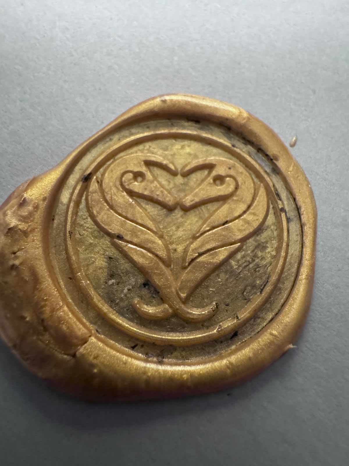 Handcrafted golden wax seal with a heart-shaped crest — an example from the TarDigRada workshop